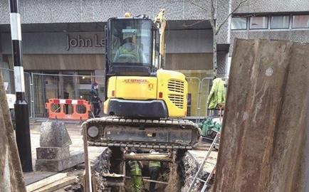 Digger over trench in high street